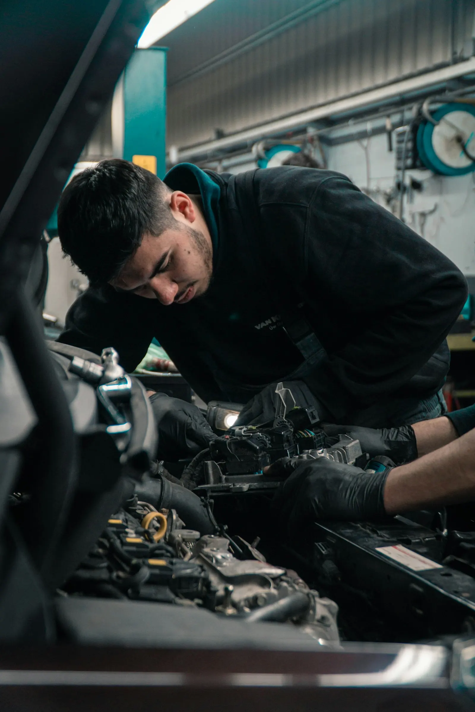 Técnico trabajando en el compartimiento del motor de un vehículo