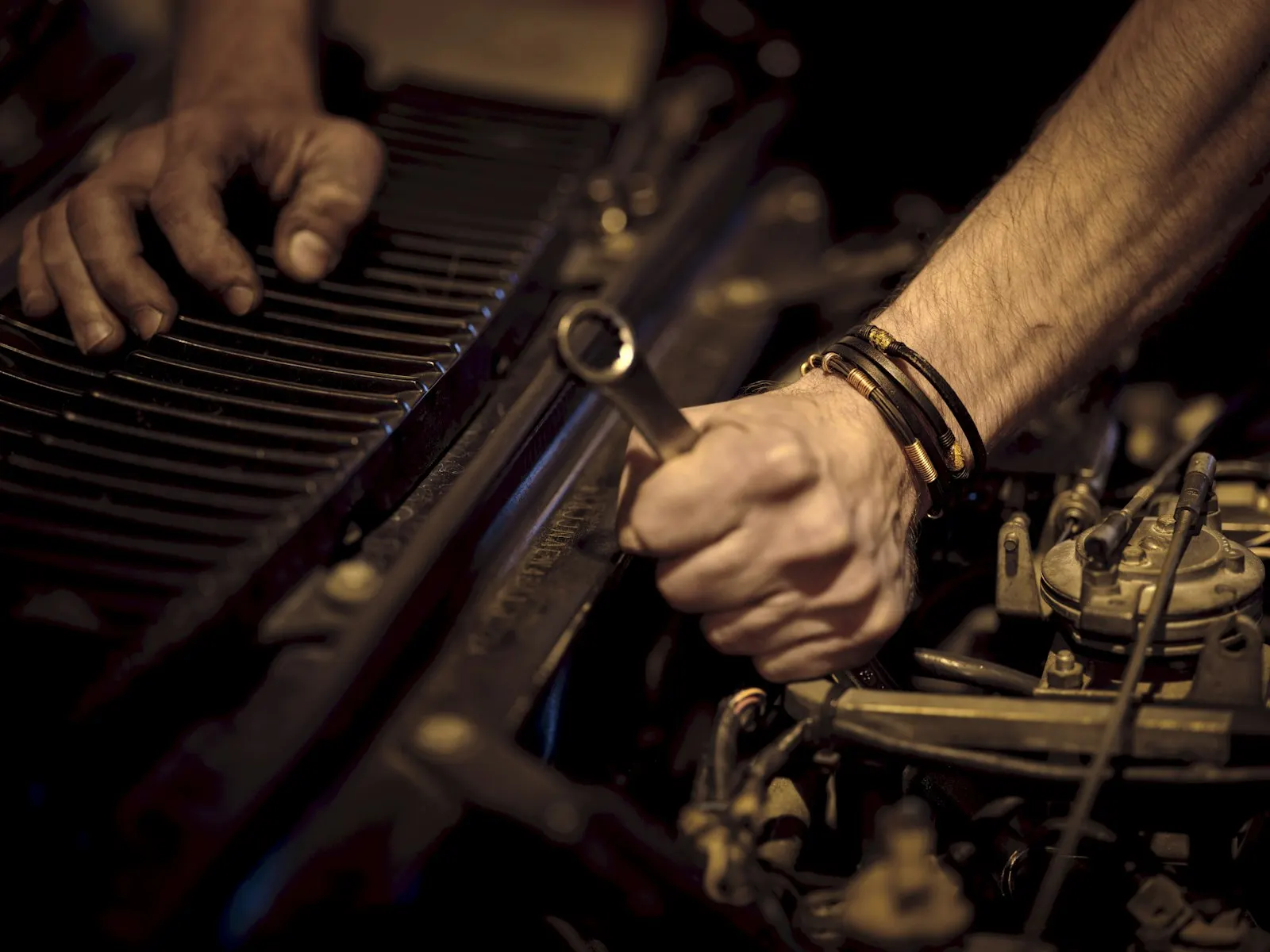 Manos de un técnico ajustando un componente del motor con una llave
